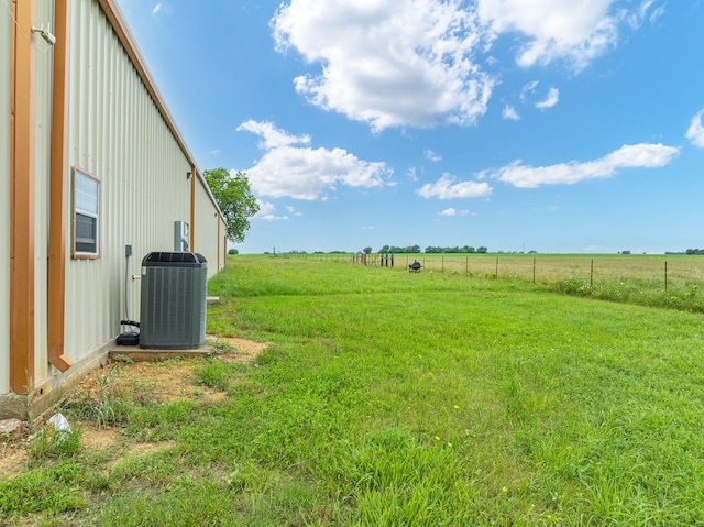 view of yard featuring central AC and a rural view