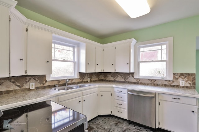 kitchen with stainless steel dishwasher, a healthy amount of sunlight, white cabinets, and sink