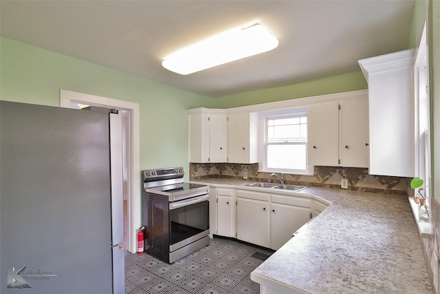 kitchen with backsplash, sink, white cabinetry, and stainless steel appliances