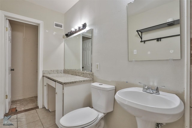 bathroom featuring toilet, tile patterned floors, and sink