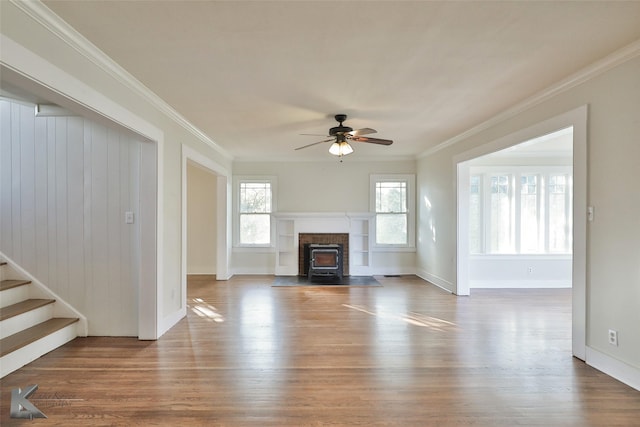 unfurnished living room featuring ceiling fan, ornamental molding, and hardwood / wood-style flooring