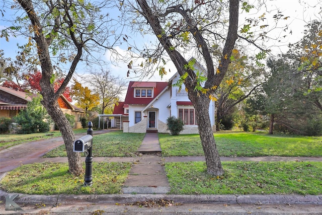 view of front of home with a carport and a front lawn