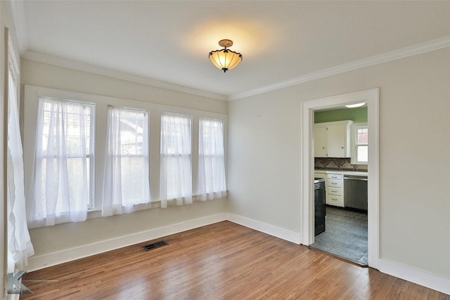 empty room featuring light hardwood / wood-style flooring and ornamental molding