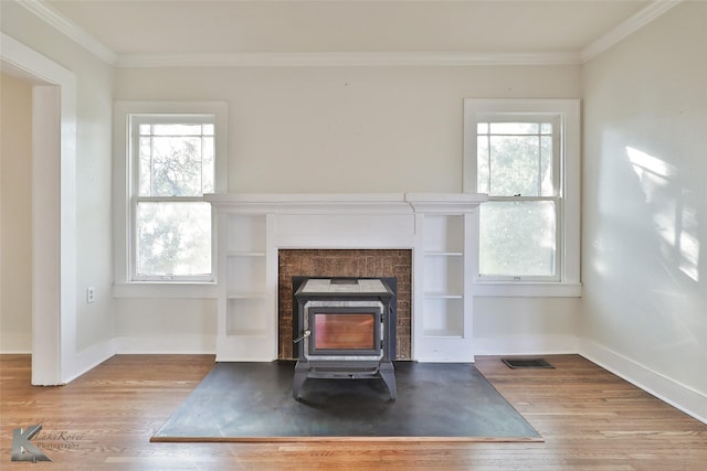 interior details with a wood stove, ornamental molding, and hardwood / wood-style flooring