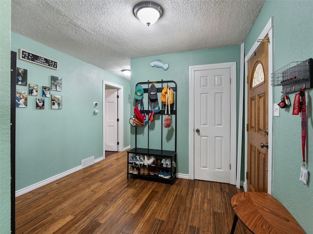 mudroom featuring a textured ceiling and dark hardwood / wood-style floors