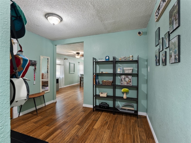 hall featuring a textured ceiling and dark hardwood / wood-style flooring