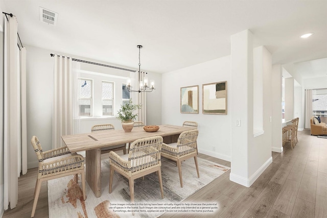 dining area featuring a notable chandelier, visible vents, baseboards, and light wood-style floors