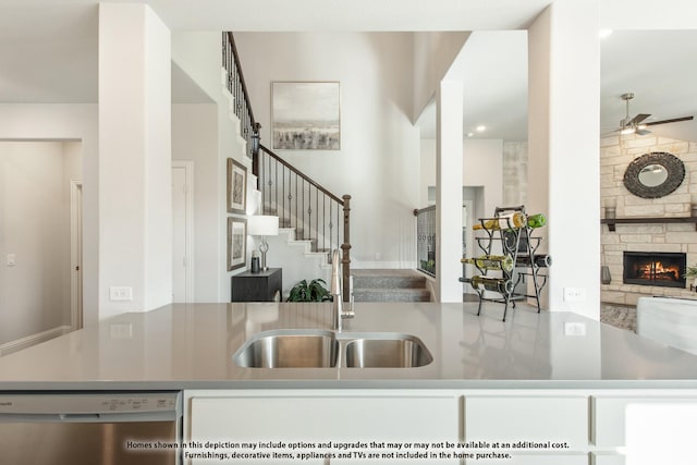 kitchen with ceiling fan, a fireplace, and dishwasher