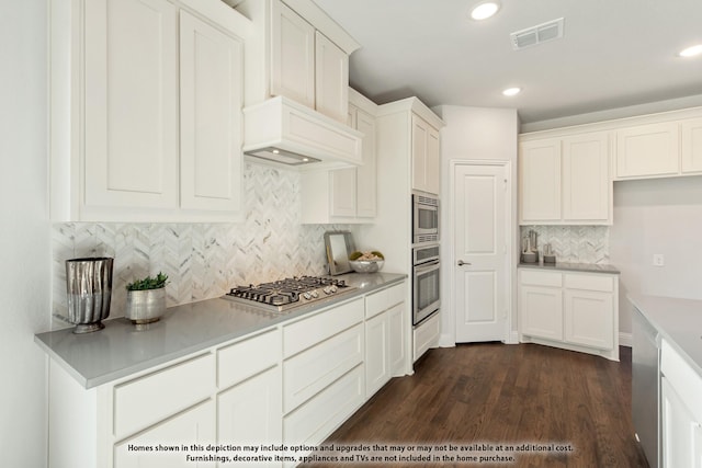 kitchen featuring white cabinetry, appliances with stainless steel finishes, dark wood-type flooring, and custom exhaust hood