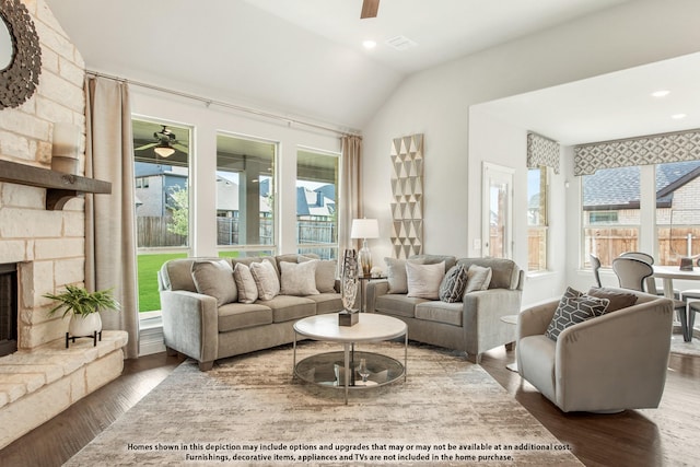 living room featuring dark hardwood / wood-style flooring, a stone fireplace, lofted ceiling, and ceiling fan