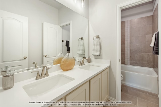 full bathroom with vanity, tiled shower / bath, tile patterned floors, and toilet