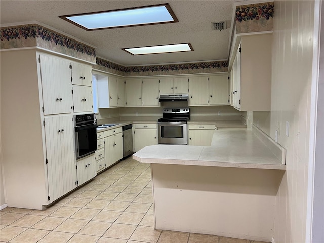 kitchen featuring kitchen peninsula, light tile patterned floors, stainless steel appliances, and a textured ceiling