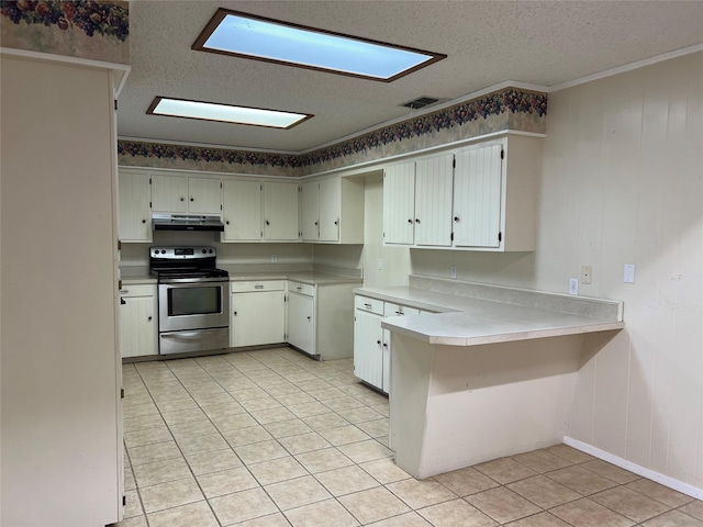 kitchen with kitchen peninsula, electric range, light tile patterned floors, and a textured ceiling