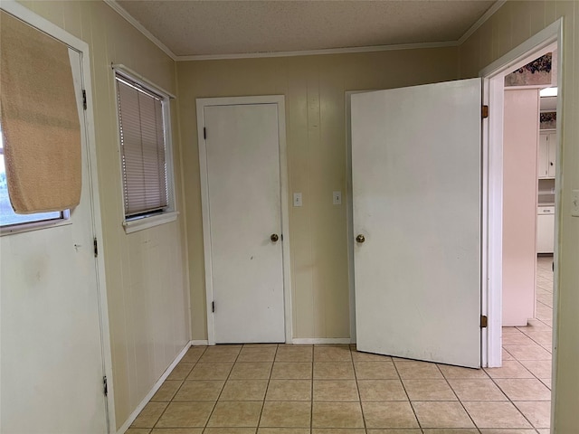 interior space featuring wood walls, light tile patterned floors, and ornamental molding