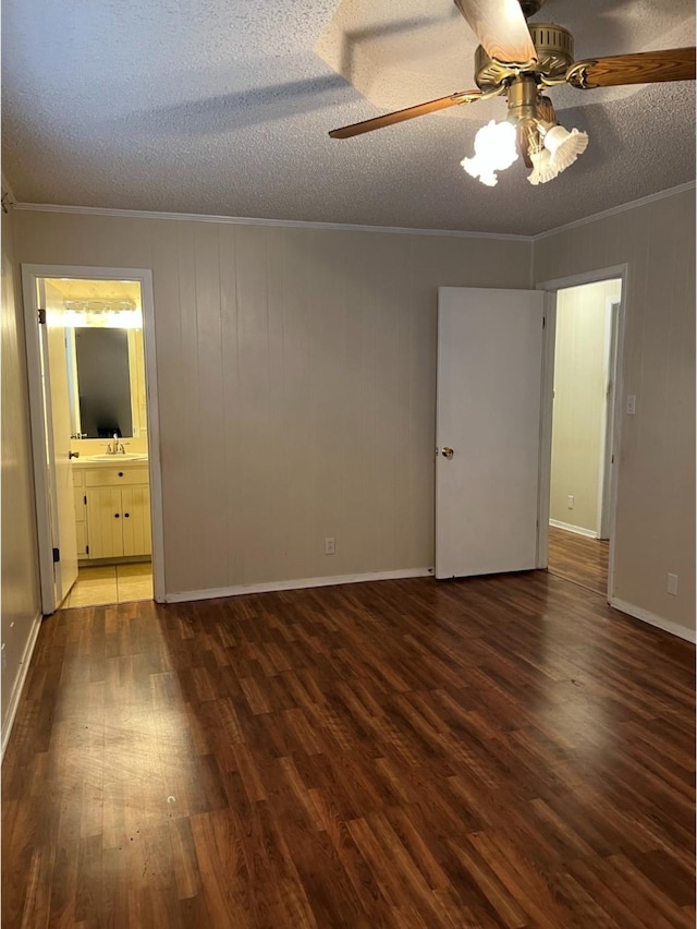 unfurnished room with sink, crown molding, dark hardwood / wood-style floors, ceiling fan, and a textured ceiling