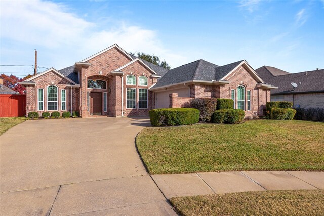 view of front of house featuring a garage and a front lawn