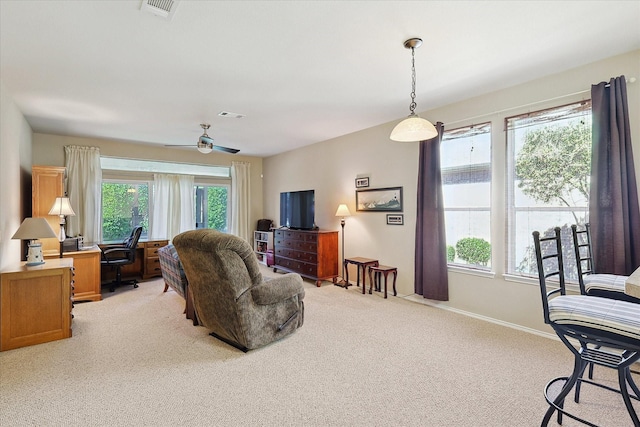 carpeted living room with ceiling fan and plenty of natural light