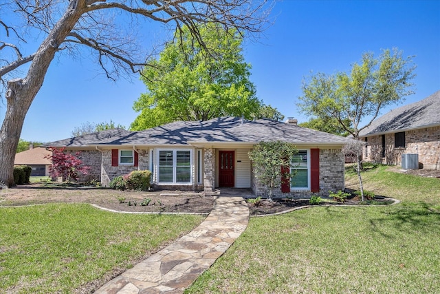 ranch-style house with central air condition unit and a front yard