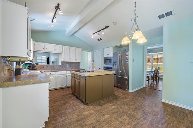 kitchen featuring dark wood-type flooring, white cabinets, appliances with stainless steel finishes, decorative light fixtures, and a kitchen island