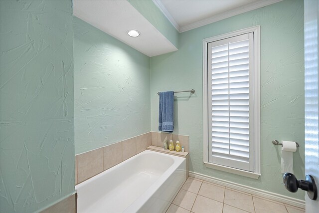 bathroom featuring tile patterned floors, a bathtub, plenty of natural light, and ornamental molding