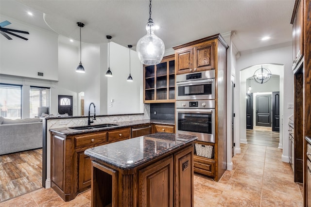 kitchen with pendant lighting, a center island, sink, kitchen peninsula, and stainless steel appliances