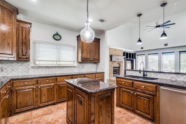 kitchen with sink, a kitchen island, stainless steel dishwasher, and plenty of natural light