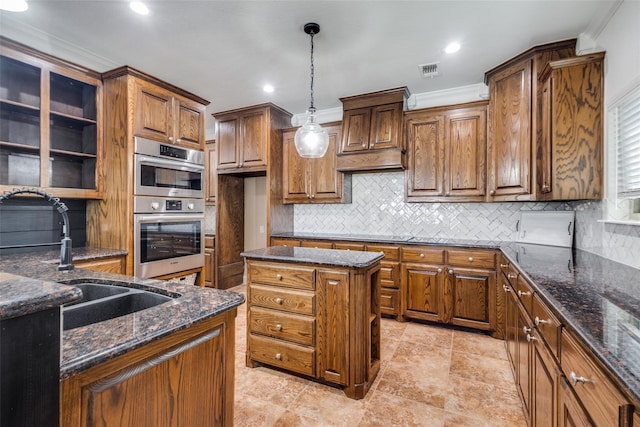 kitchen with crown molding, dark stone countertops, stainless steel double oven, and sink