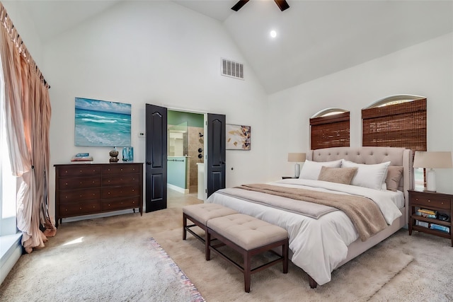 carpeted bedroom featuring high vaulted ceiling, ensuite bath, and ceiling fan