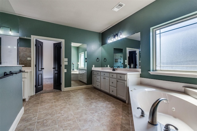 bathroom featuring tile patterned floors, a tub to relax in, and vanity