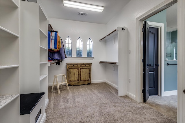 walk in closet featuring light carpet