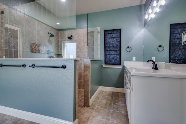 bathroom with a tile shower, tile patterned floors, and vanity