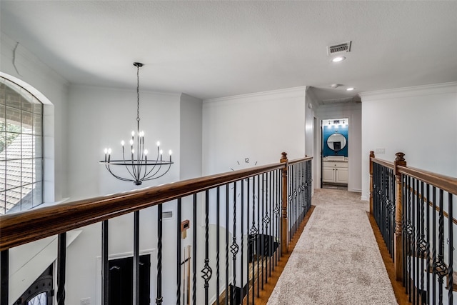 hall with hardwood / wood-style flooring, crown molding, and a chandelier