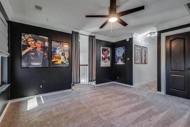 home theater featuring ceiling fan, light colored carpet, and ornamental molding