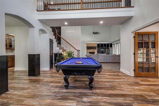 playroom featuring hardwood / wood-style floors, ceiling fan, a towering ceiling, and billiards