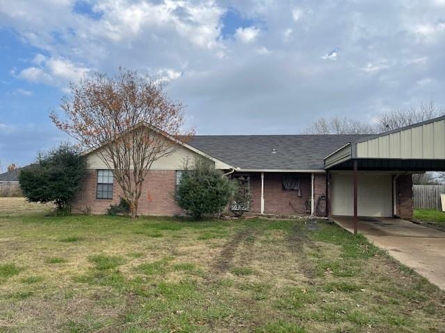 ranch-style home featuring a front lawn and a carport