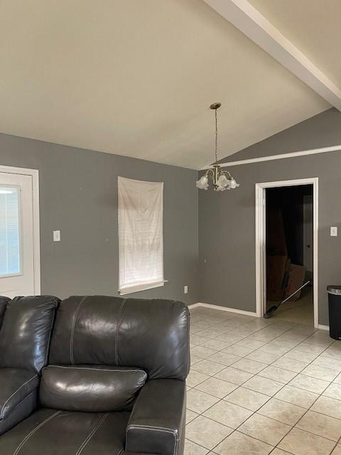 living room with lofted ceiling, a chandelier, and light tile patterned floors