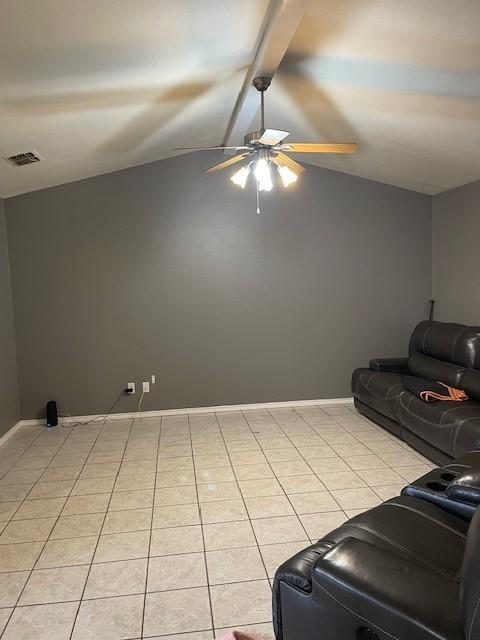 living room featuring lofted ceiling, light tile patterned floors, and ceiling fan