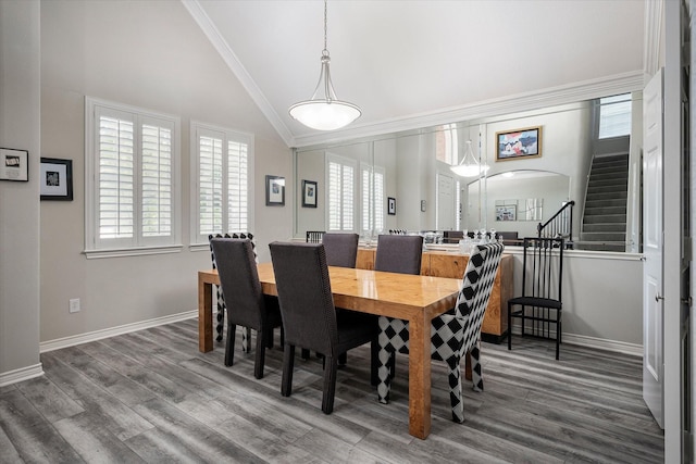 dining space with hardwood / wood-style floors, lofted ceiling, and crown molding