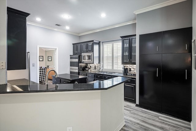 kitchen with decorative backsplash, crown molding, kitchen peninsula, and stainless steel appliances