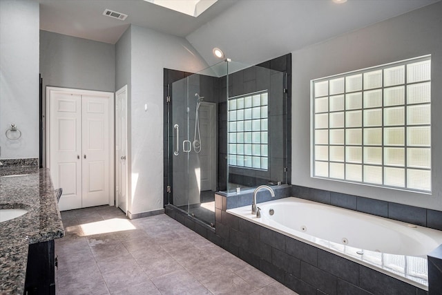 bathroom with tile patterned flooring, vanity, lofted ceiling, and plus walk in shower