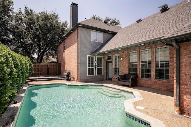 view of pool featuring a patio and a grill