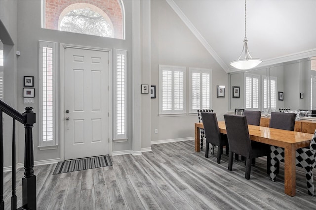 entryway with a wealth of natural light, high vaulted ceiling, and ornamental molding