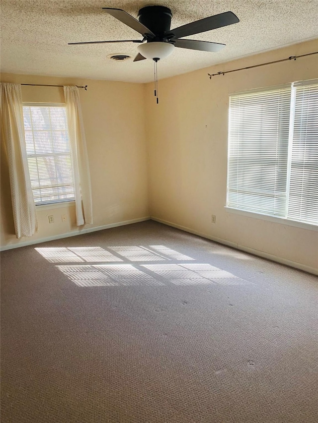 spare room featuring carpet flooring, ceiling fan, and a textured ceiling