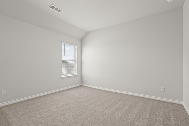 carpeted spare room featuring lofted ceiling