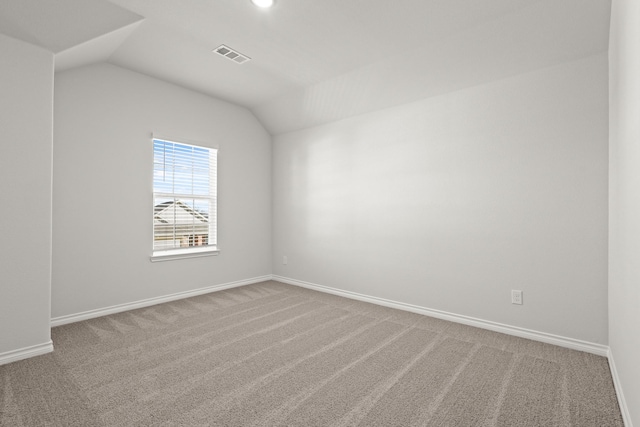 carpeted empty room with lofted ceiling