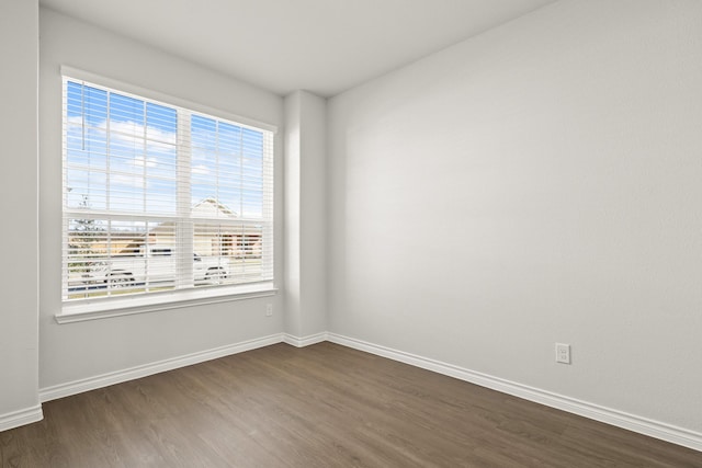 empty room with dark hardwood / wood-style flooring