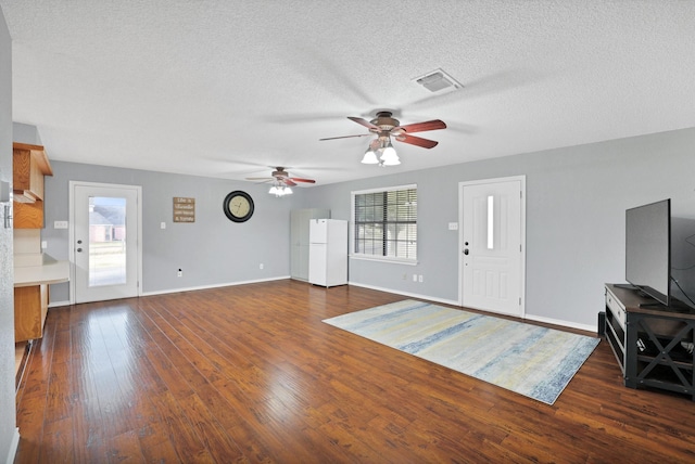 unfurnished living room with dark hardwood / wood-style floors, ceiling fan, and a textured ceiling