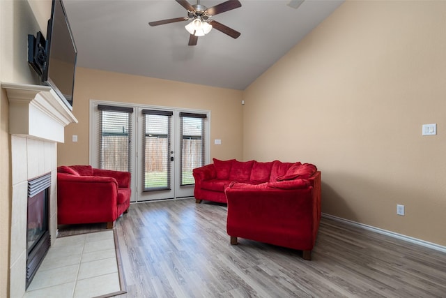 living room with ceiling fan, french doors, lofted ceiling, a fireplace, and hardwood / wood-style flooring