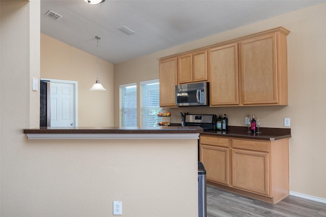 kitchen with kitchen peninsula, appliances with stainless steel finishes, pendant lighting, light hardwood / wood-style floors, and lofted ceiling