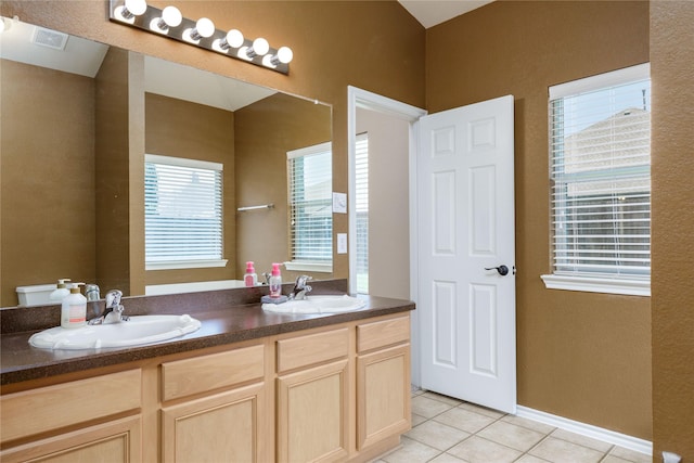 bathroom featuring tile patterned flooring, vanity, and plenty of natural light